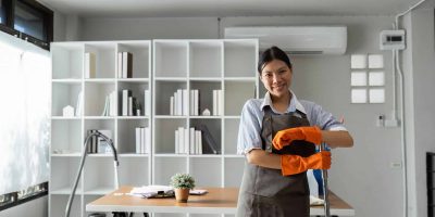 Female housekeeper smile and wearing glove, preparing to clean office