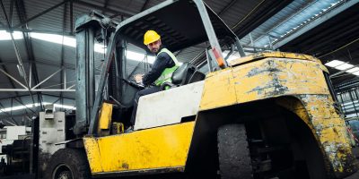 Industrious Engineer Operating Forklift in Warehouse. Efficient Forklift Driving in Factory.