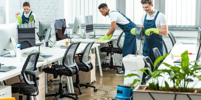 multicultural team of cleaners working in modern open space office